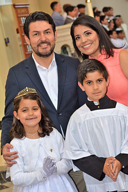 Writer Leonor Clavijo stands with her husband and children outside their church. In this column, she writes about how some families face a dilemma of which Mass – English or Spanish – to attend.