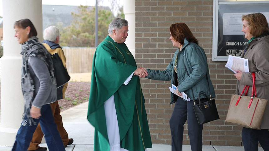 Father Bill Walsh, O.S.F.S. greets people after Mass.