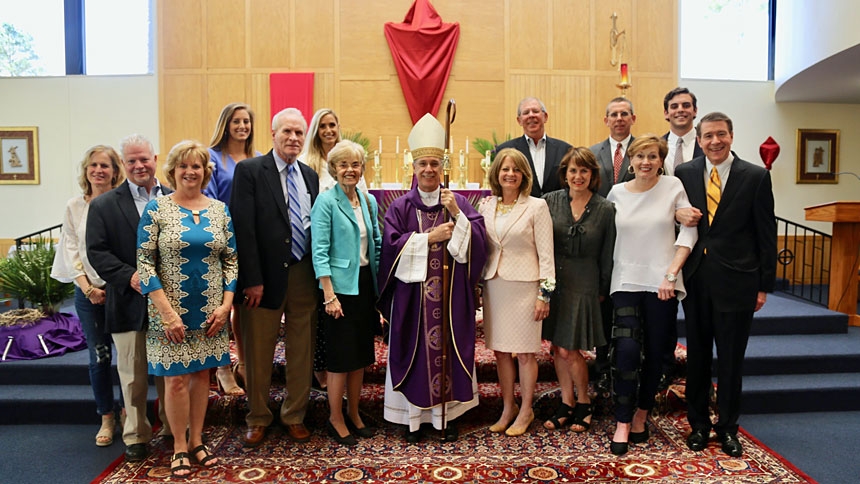 Laurie Huger, pictured to the right of the bishop, is honored during a Mass April 10.