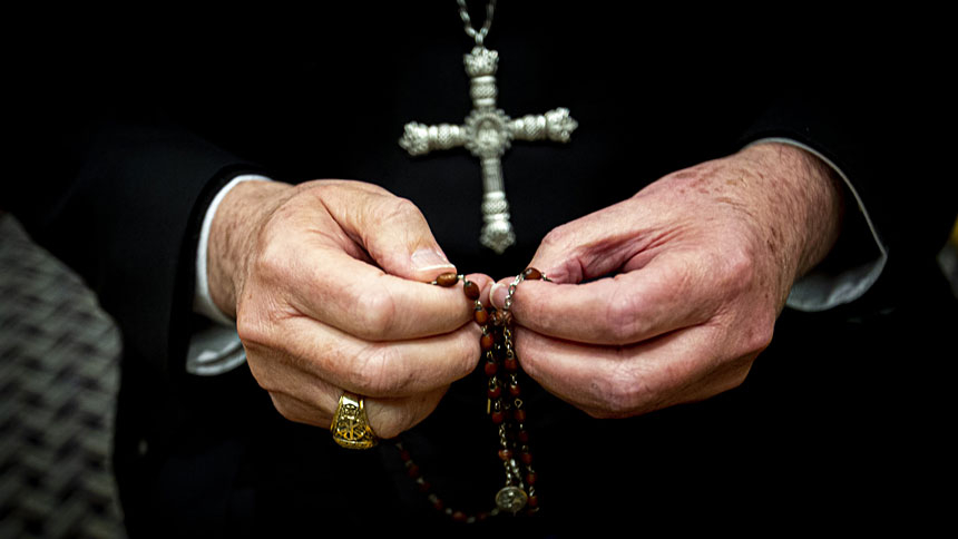 Priest praying rosary