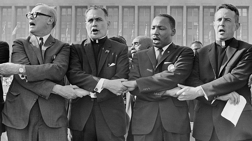 Holy Cross Father Theodore Hesburgh, second from left, joins hands with the Rev. Martin Luther King Jr., the Rev. Edgar Chandler and Msgr. Robert J. Hagarty of Chicago, far right, in 1964 at the Illinois Rally for Civil Rights in Chicago's Soldier Field. (CNS photo/courtesy University of Notre Dame)
