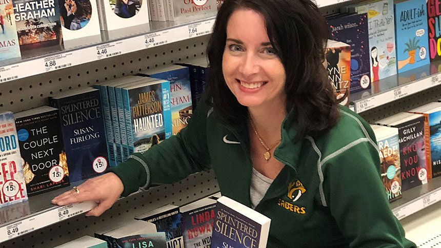 Mystery novelist Susan Furlong holds a paperback copy of her book "Splintered Silence" from the book shelves of a department store in Champaign, Ill. (CNS photo/Susan Furlong Facebook page via The Catholic Post)