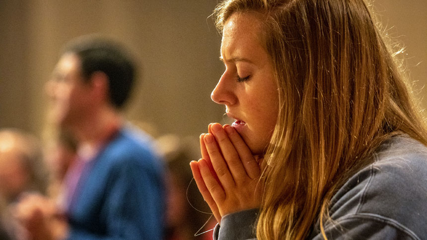 A young woman prays during a pilgrimage. (CNS photo: Lisa Johnston, St. Louis Review)