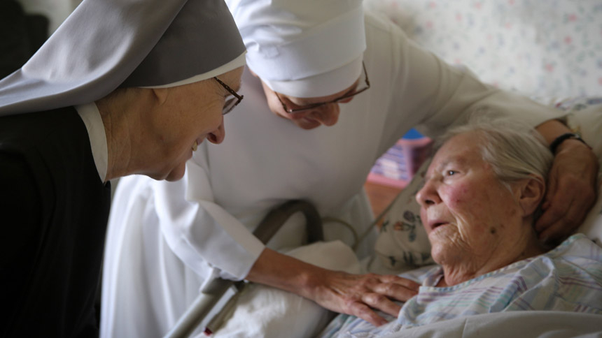 Sister Margaret Patricia Lennon and Sister Anthony Selewicz offer support to a frail resident at Little Sisters of the Poor Jeanne Jugan Residence in San Pedro, Calif., in this 2016 photo. The Little Sisters of the Poor care for the elderly poor in assisted living facilities throughout the U.S. and frequently accompany the dying. (CNS photo/courtesy Little Sisters of the Poor)