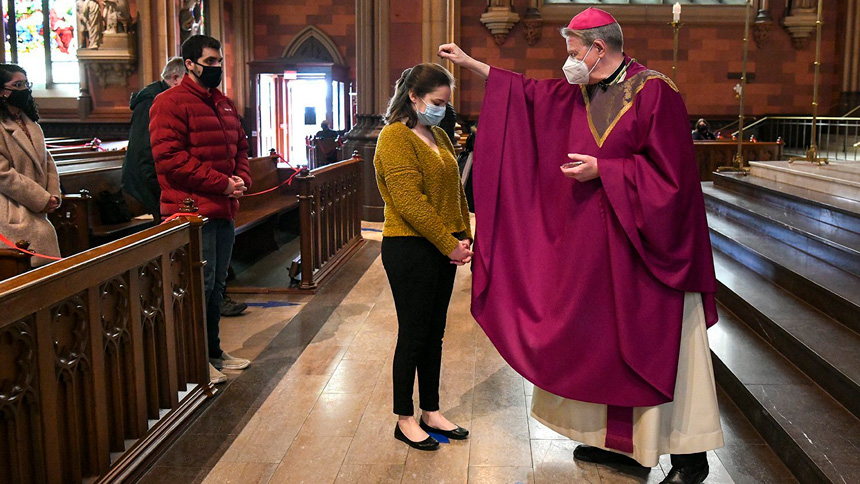 Bishop Edward B. Scharfenberger of Albany, N.Y., sprinkles ashes on parishioners during Mass at the Cathedral of the Immaculate Conception Feb. 17, 2021, amid the coronavirus pandemic. Lent 2022 begins March 2, which is Ash Wednesday. (CNS photo/Cindy Schultz, The Evangelist)