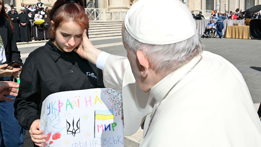 Pope Francis greets a girl while meeting with a group of Ukrainians after his weekly general audience in St. Peter's Square at the Vatican April 27, 2022. She was one of 11 orphaned children who escaped Ukraine and found assistance in early March from an Italian Catholic organization. (CNS photo/Vatican Media)