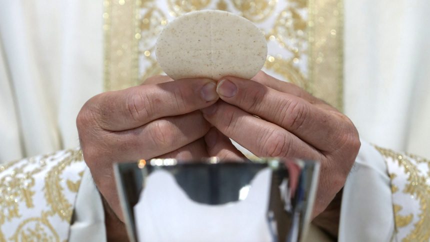 A priest holds the Eucharist in this illustration taken May 27, 2021. The "sense of mystery" and awe Catholics should experience at Mass is prompted by an awareness of sacrifice of Christ and his real presence in the Eucharist, Pope Francis said in a document released June 29, 2022. (CNS photo/Bob Roller)