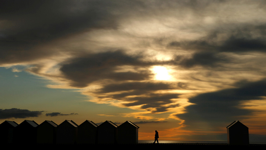 A man walks between beach huts at sunset in Cayeux-sur-Mer, France, June 12, 2020. (CNS photo/Pascal Rossignol, Reuters)