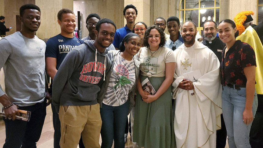 Father Robert Boxie III, center right, Catholic chaplain of Howard University in Washington, is pictured with students at the Basilica of the National Shrine of the Immaculate Conception in Washington Sept. 17, 2022. The group attended the 25th anniversary pilgrimage for the Our Mother of the Africa Chapel at the basilica, which included lunch and a tour. (CNS photo/ Samantha Smith, The Georgia Bulletin via Catholic Standard)