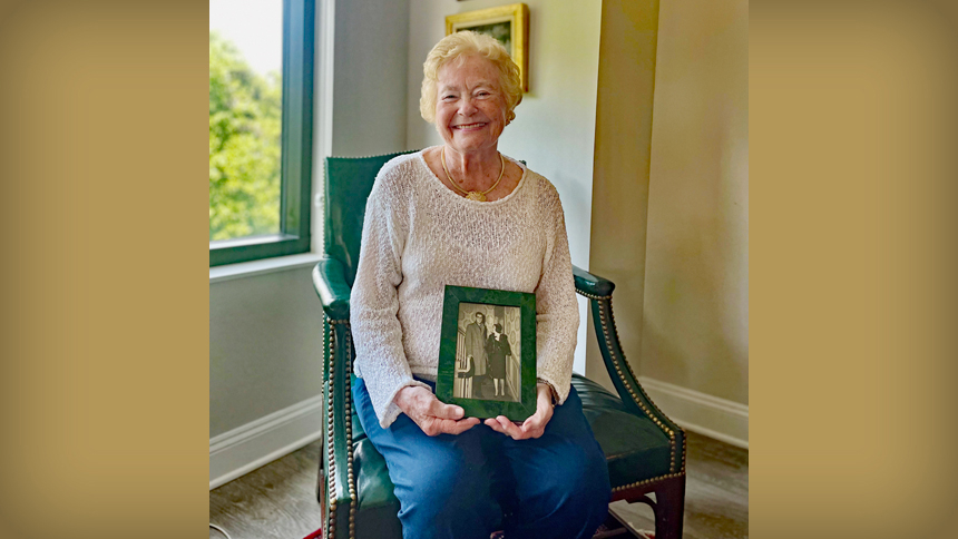 In her Raleigh home, Anne Stahel holds a framed photograph of her husband Ed and herself leaving for their honeymoon.