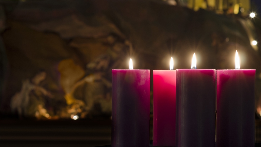 Advent candles in front of blurred nativity