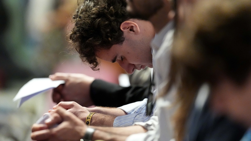 A young man bows his head in prayer during Holy Thursday’s Mass of the Lord’s Supper at the Altar of the Chair in St. Peter’s Basilica at the Vatican April 17, 2025. (CNS photo/Lola Gomez)