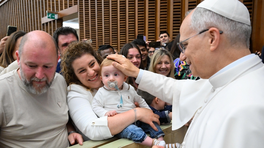 Pope Leo XIV greets a child during a meeting with officials and employees of the Roman Curia, Vatican City State and the Diocese of Rome in the Paul VI Audience Hall at the Vatican May 24, 2025. (CNS photo/Vatican Media)