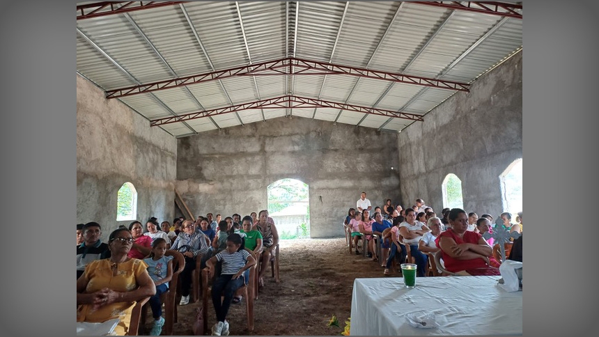 People celebrate Mass in church awaiting installation of concrete floors and completion of construction. 