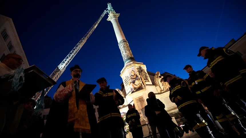 Father Elio Lops, chaplain of Rome's firefighters, blesses firefighters before they place a wreath of flowers on a tall Marian statue overlooking the Spanish Steps in Rome Dec. 8, 2025, the feast of the Immaculate Conception. (CNS photo/Lola Gomez)