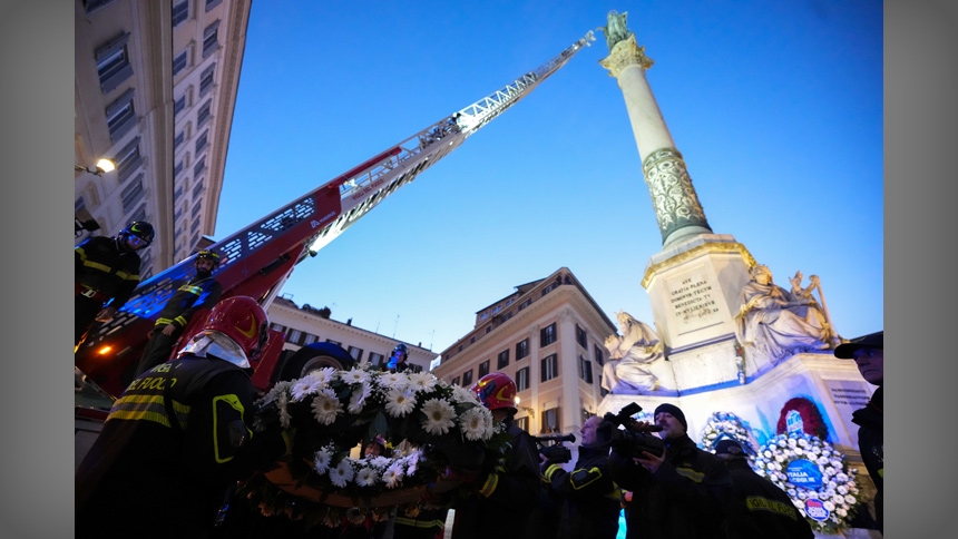 Firefighters hand over a floral wreath to Roberto Leo, a senior firefighter, who will place it on the Marian statue atop the Column of the Immaculate Conception near the Spanish Steps in Rome Dec. 8, 2025, during celebrations for the feast of the Immaculate Conception. (CNS photo/Lola Gomez)