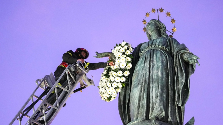Roberto Leo, a senior firefighter, places a wreath of flowers on a Marian statue near the Spanish Steps in Rome Dec. 8, 2025, the feast of the Immaculate Conception. (CNS photo/Lola Gomez)