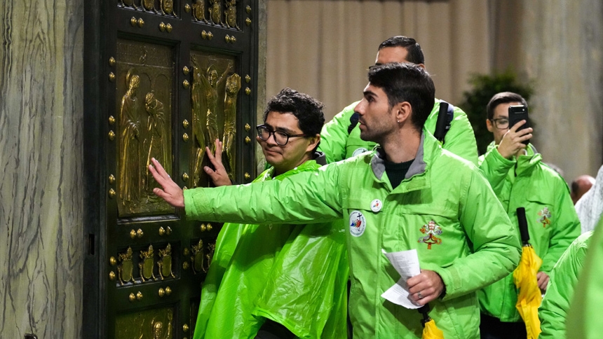 Jubilee volunteers touch the Holy Door at St. Peter’s Basilica at the Vatican Jan. 5, 2026, the last day it remained open before Pope Leo XIV officially closed it Jan. 6 to mark the end of the Holy Year. (CNS photo/Lola Gomez)