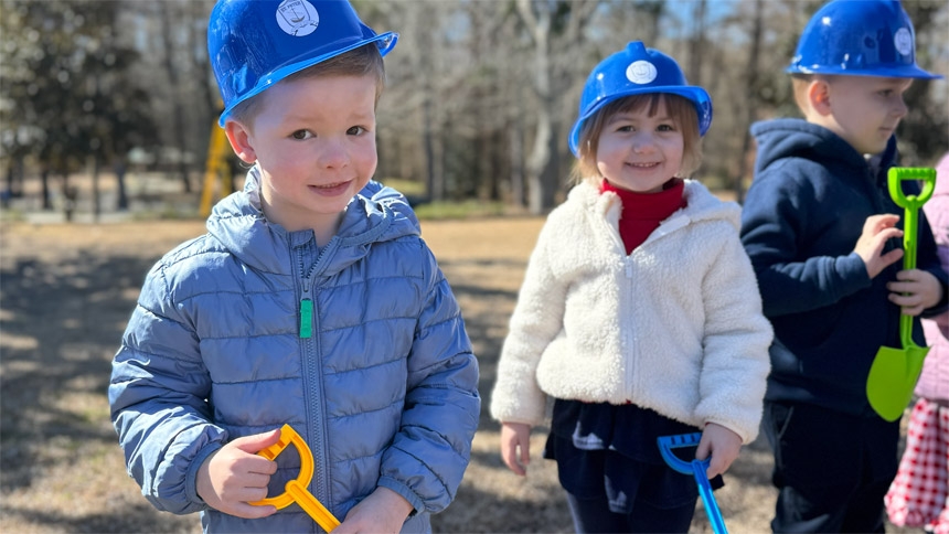 McNair Thompson and Ellie Morse, PK3 students, smile at the blessing and groundbreaking for their new school building.  