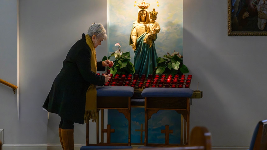 Elaine Howard visits the prayer candles Jan. 30, 2026 at St. Stanislaus Church in Castle Hayne. 