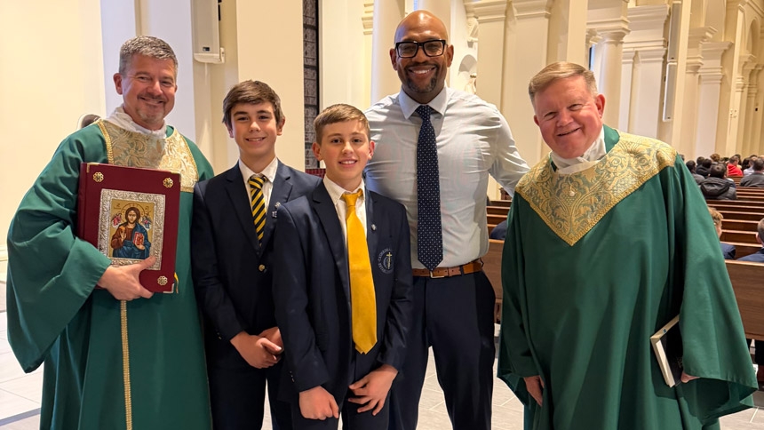(Left to right) Deacon Mike Alig, Cathedral students Owen and Luke Dusel, Witherspoon and Monsignor David Brockman smile for a photo. 