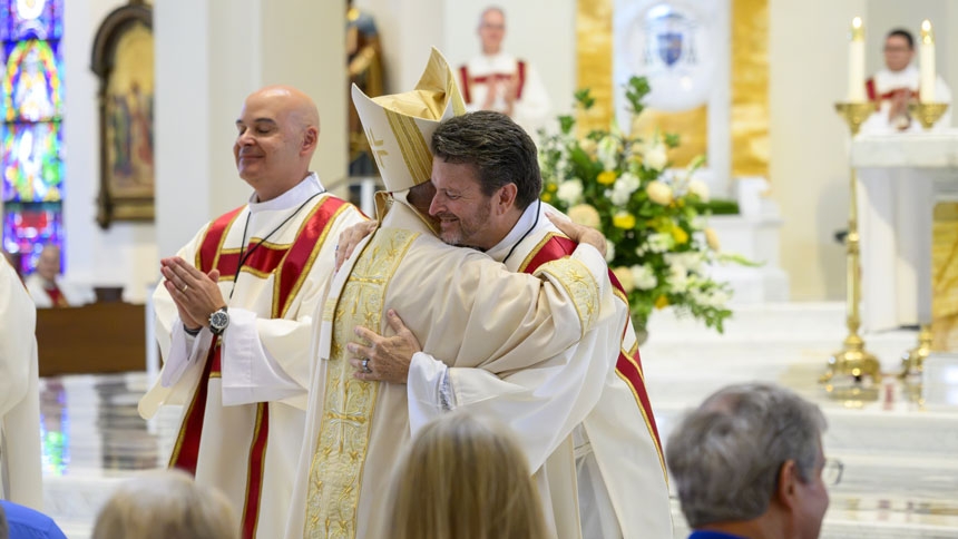 Deacon Gary Rourke and Bishop share sign of peace.