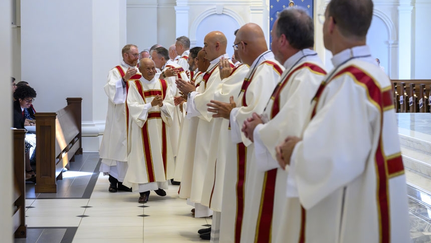 Deacons give sign of peace to the newly ordained.