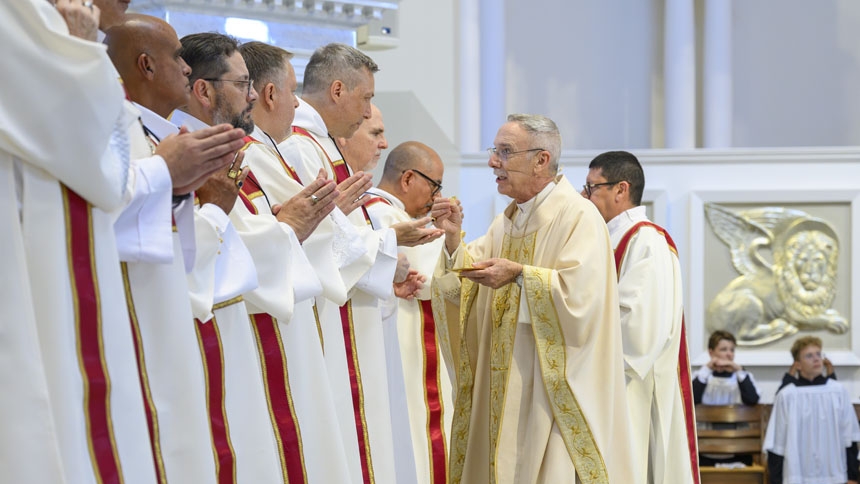 The new deacons receive Communion during Mass.