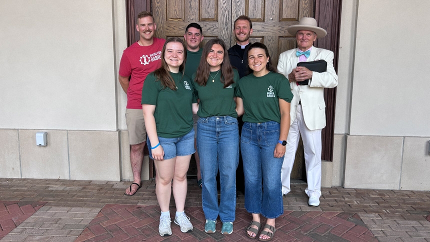 The team joins host Jim Scofield (far right) for a photo after Mass at St. Catherine of Siena Church in Wake Forest.