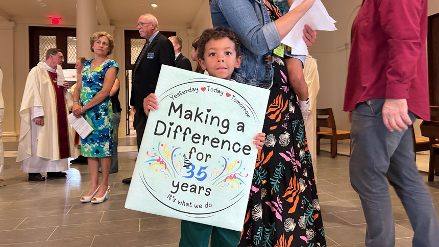 Children participated in the procession before the Aug. 5 Mass to honor the jubilee of St. Francis. This poster represented the preschool’s history at the parish.