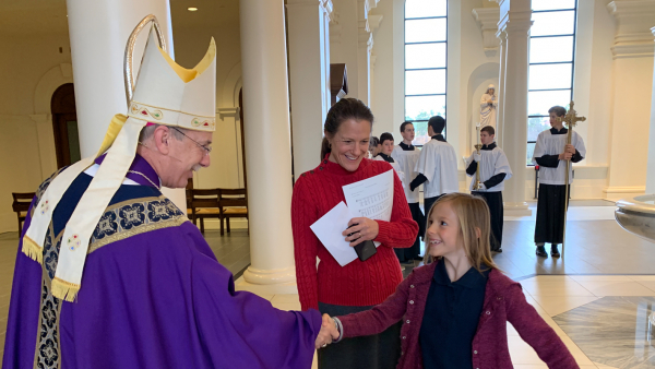 Bishop Zarama greets student at Homeschool Mass