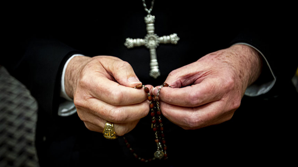 Priest praying rosary