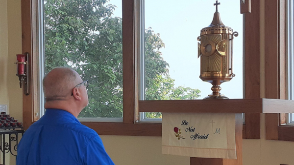 David Zientarski, a hospice nurse, prays before the Eucharist in the adoration chapel at St. Anthony of Padua Parish in Lorain, Ohio, July 7, 2021. He said his daily visits on the way to see clients nourishes his soul and gives him the strength to handle any difficulties he may face. (CNS photo/Dennis Sadowski)