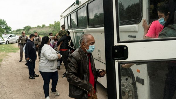 Migrant families from Venezuela seeking asylum board a U.S. Border Patrol's bus in Del Rio, Texas, May 27, 2021, to be transported after crossing the Rio Grande into the United States from Mexico. (CNS photo/Go Nakamura, Reuters)