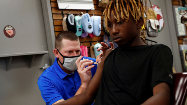 Pharmacist Shane Dixon administers the second dose of the Pfizer vaccine against COVID-19 to Jamartez Stroud, 12, at the Watson Pharmacy in Fordyce, Ark., Aug. 12, 2021. (CNS photo/Shannon Stapleton, Reuters)