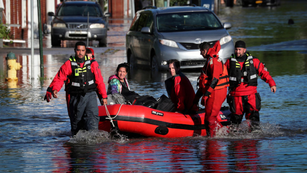 First responders in Mamaroneck, N.Y., pull local residents in a boat Sept. 2, 2021, as they rescue people trapped by floodwaters after the remnants of Tropical Storm Ida. (CNS photo/Mike Segar, Reuters)