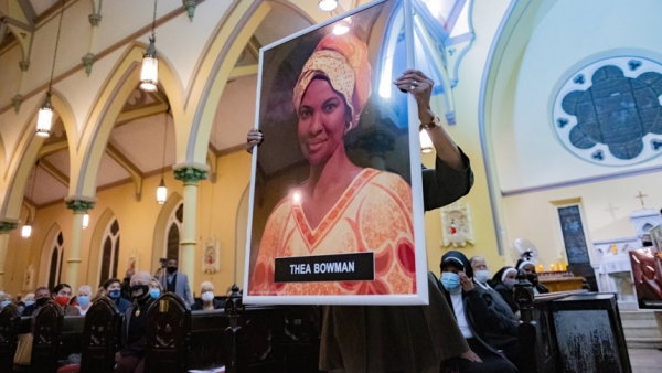 Theresa Wilson Favors, former director of the Office of Black Catholic Ministries for the Archdiocese of Baltimore, carries a portrait of Sister Thea Bowman, a Franciscan Sister of Perpetual Adoration from Canton, Miss., during the opening procession of an All Saints' Day Mass at St. Ann Catholic Church in Baltimore Nov. 1, 2021. Sister Bowman, who died in 1990 at age 52 from cancer, is one of six African Americans who are sainthood candidates and whose causes advocates hope will be expedited by Pope Franci