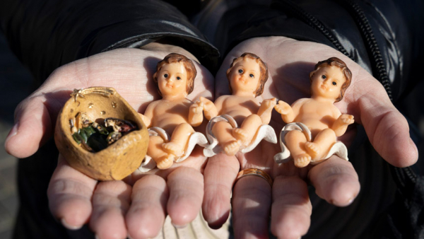 A figurines of the baby Jesus are seen as people gather in St. Peter's Square for the Angelus led by Pope Francis at the Vatican Dec. 12, 2021. Children brought their Nativity figurines of baby Jesus to be blessed by the pope. (CNS photo/Vatican Media)