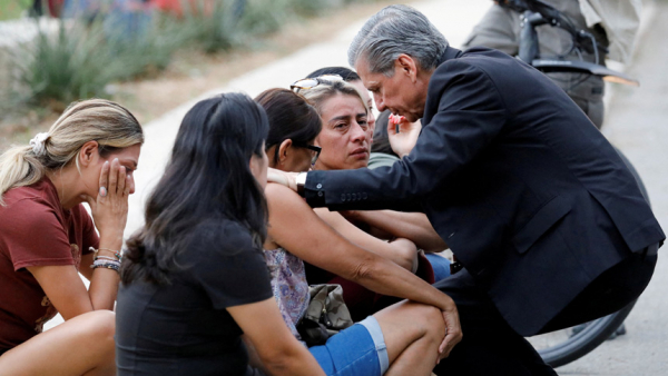 Archbishop Gustavo Garcia-Siller of San Antonio comforts people outside the SSGT Willie de Leon Civic Center, where students had been transported from Robb Elementary School after a shooting, in Uvalde, Texas, May 24, 2022. (CNS photo/Marco Bello, Reuters)