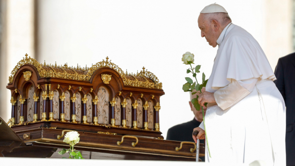 Pope Francis carries a white rose as he approaches a reliquary containing the relics of St. Thérèse of Lisieux before the start of his general audience in St. Peter's Square at the Vatican June 7, 2023. He announced he was planning on issuing an apostolic letter dedicated to her for the 150th anniversary of her birth. (CNS photo/Lola Gomez)