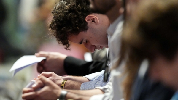 A young man bows his head in prayer during Holy Thursday’s Mass of the Lord’s Supper at the Altar of the Chair in St. Peter’s Basilica at the Vatican April 17, 2025. (CNS photo/Lola Gomez)