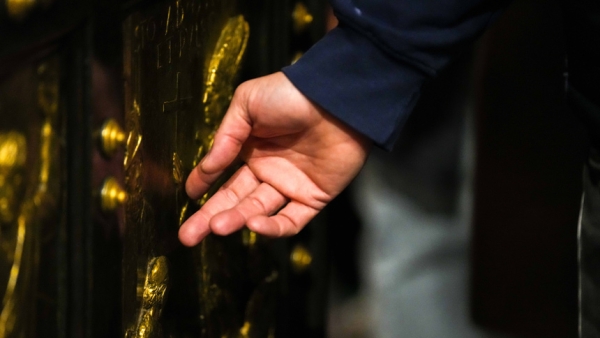 A pilgrim touches the Holy Door at St. Peter’s Basilica at the Vatican Jan. 5, 2026, the last day it remained open before Pope Leo XIV officially closed it Jan. 6 to mark the end of the Holy Year. (CNS photo/Lola Gomez)