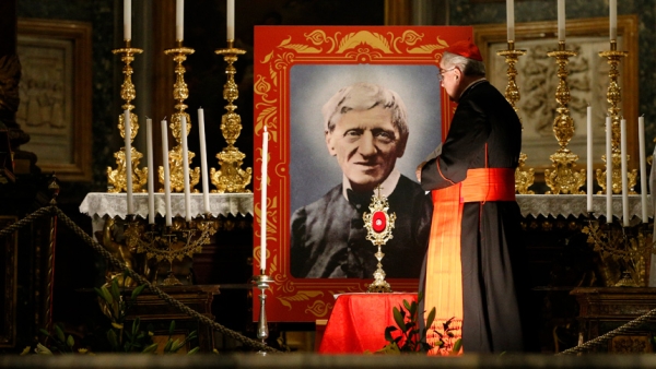 In this file photo, Cardinal Stanislaw Rylko, who at the time was archpriest of the Basilica of St. Mary Major, walks past an image of St. John Henry Newman during a vigil in advance of his canonization, at the Basilica of St. Mary Major in Rome Oct. 12, 2019. (CNS photo/Paul Haring)