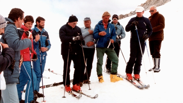 In this 1984 file photo, St. John Paul II, in a black ski jacket and hat, prays with a group of skiers before heading down a slope in Italy in 1984. The pontiff, who had enjoyed skiing in his native Poland, slipped away to ski a number of times while he led the worldwide church. (CNS photo/Arturo Mari, L'Osservatore Romano)