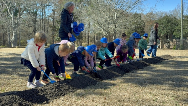 Students use shovels to turn dirt at the groundbreaking. 