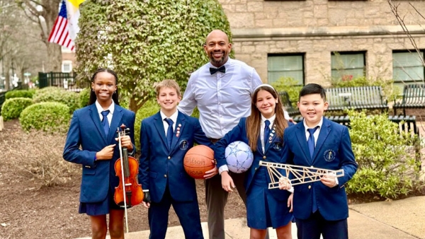 Mr. Spoon (center) stands outside of the school with (left to right) students Faith Igbinovia, Will Ferris, Paloma Zampieri and Bao Tin Tran. 