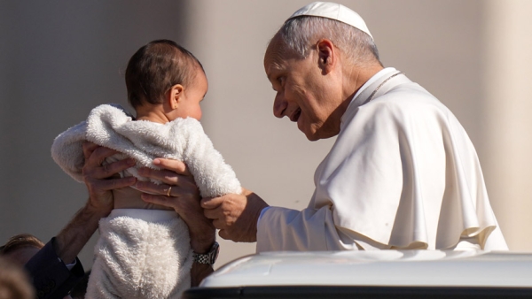 Pope Leo XIV greets a child from the popemobile while riding around St. Peter’s Square at the Vatican before his weekly general audience April 8, 2026. (CNS photo/Lola Gomez)
